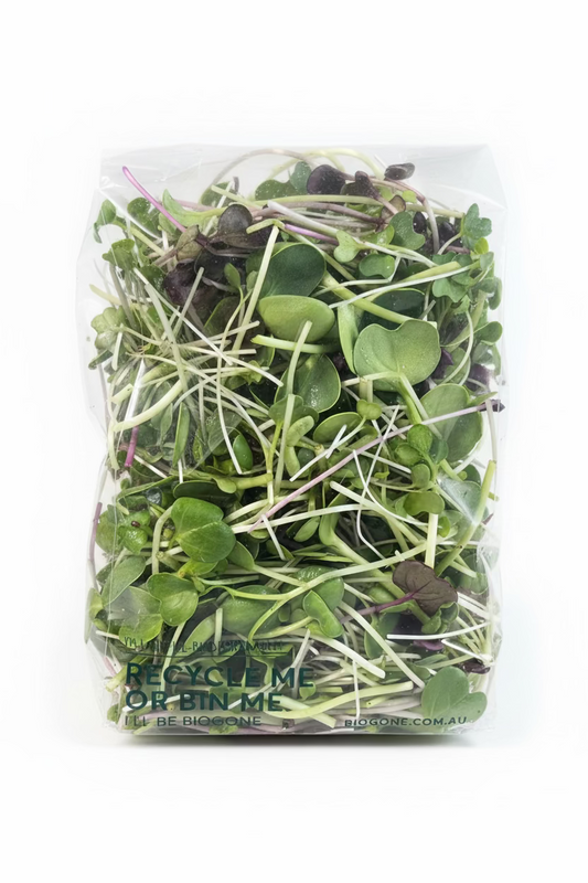 Packaged microgreens in a clear plastic bag on a wooden surface